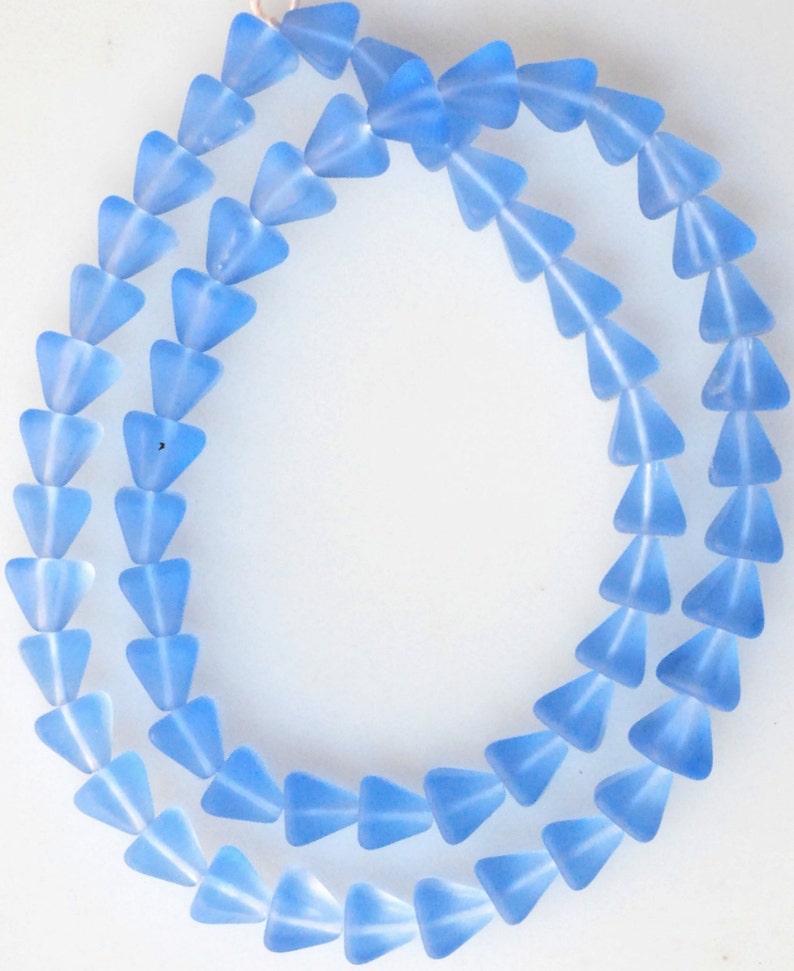 May include: A strand of light blue glass beads in a triangle shape.