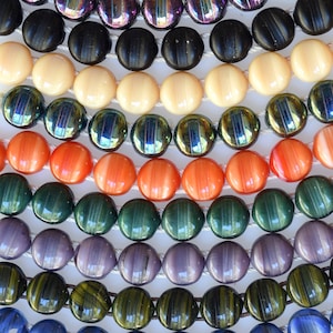 May include: A collection of round, colourful beads with various patterns and textures. The beads are arranged in rows, creating a visually appealing display. The beads are made of glass and have a smooth, polished finish.