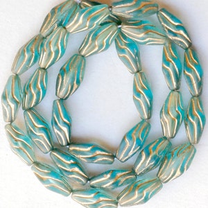 May include: A strand of turquoise blue glass beads with gold accents. The beads are faceted and have a wavy pattern.