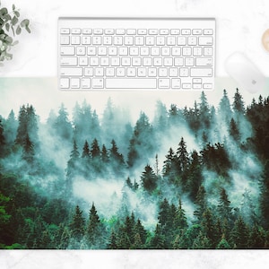 Puede incluir: Una escena de bosque verde y azul con niebla y neblina. Los árboles son altos y densos, creando una sensación de profundidad y misterio. La niebla agrega una calidad suave y etérea a la imagen.