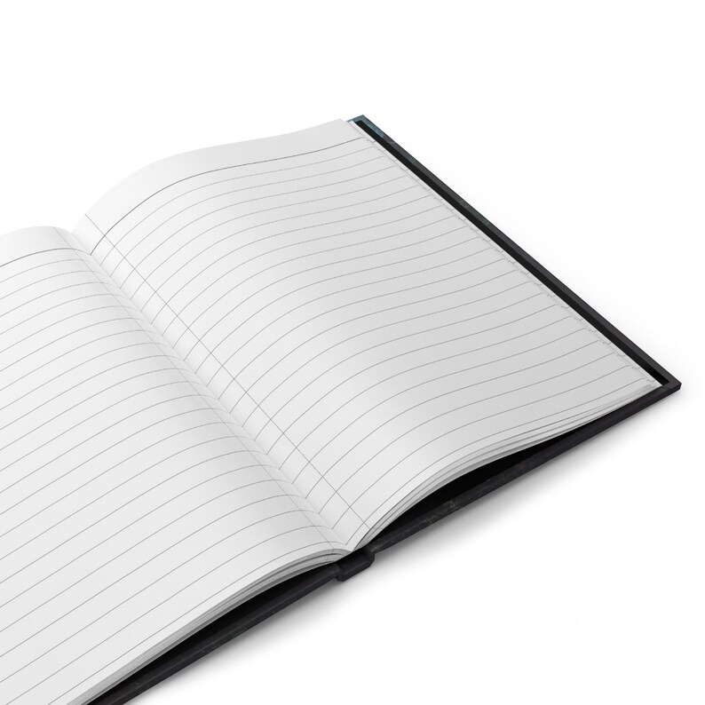 May include: A black notebook with lined pages is open and lying flat on a white surface.