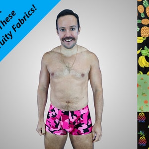 May include: A man wearing pink and black camouflage print boxer shorts. The image is surrounded by four different fabric swatches with fruit prints: pineapples, bananas, citrus fruits, and pineapples with flamingos.