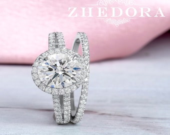 May include: A three-piece diamond engagement ring set with a large round center stone surrounded by smaller diamonds. The ring is set in white gold and features a halo design.