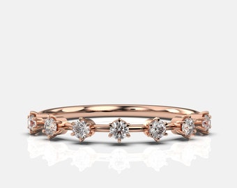 May include: A delicate rose gold band with a row of small, round diamonds set in a prong setting.