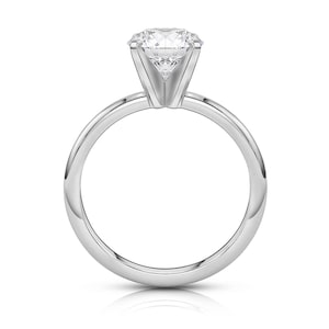 May include: A silver solitaire engagement ring with a round brilliant cut diamond.