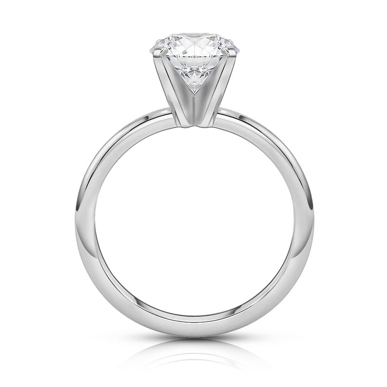 May include: A silver solitaire engagement ring with a round brilliant cut diamond.