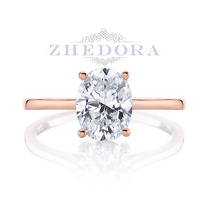 Puede incluir: Un anillo de compromiso de oro rosa con un gran diamante de forma ovalada.