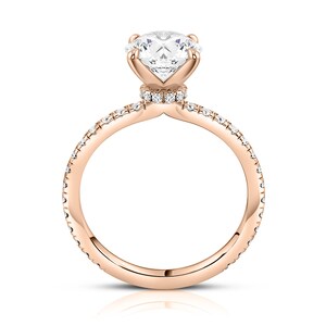 May include: A rose gold engagement ring with a round brilliant cut diamond center stone and a pave diamond band.