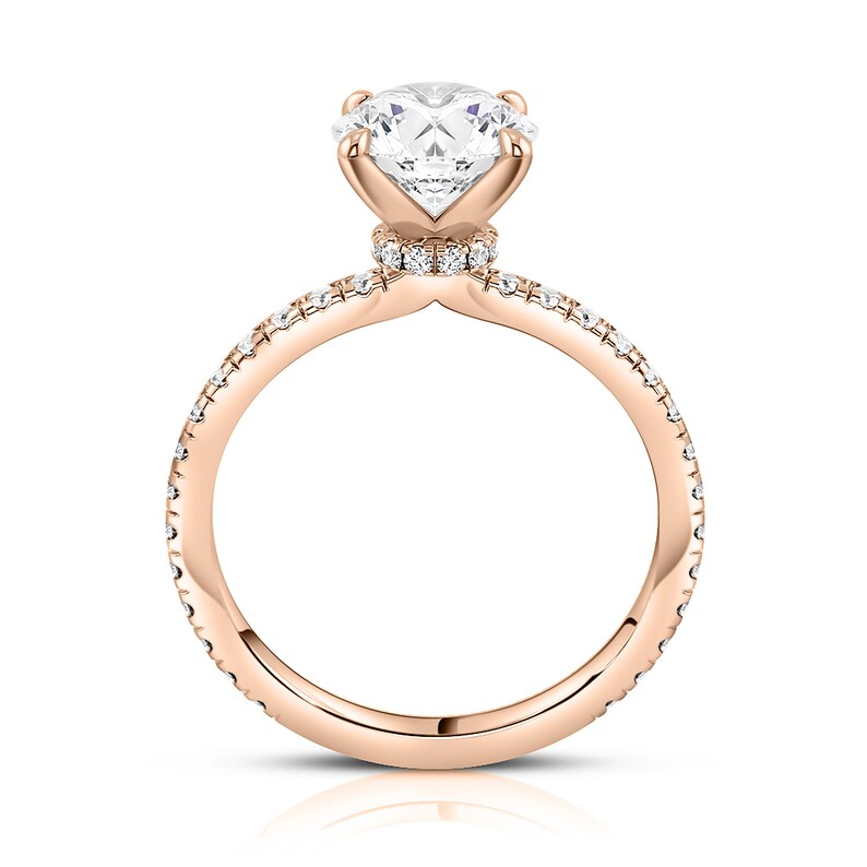 May include: A rose gold engagement ring with a round brilliant cut diamond center stone and a pave diamond band.