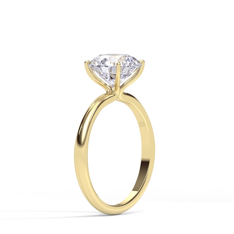 May include: A gold engagement ring with a large, clear, round diamond.