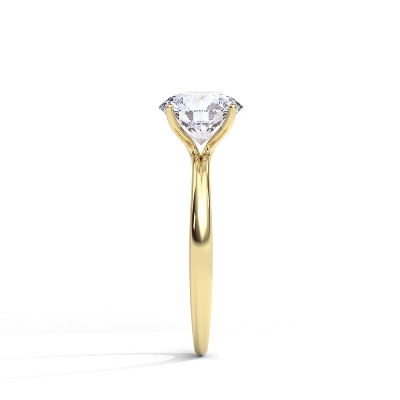May include: A gold engagement ring with a large, clear, round diamond.