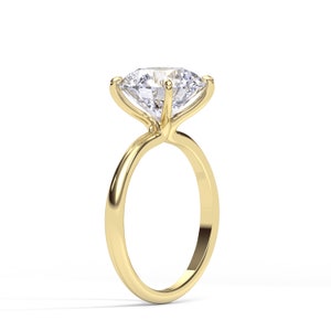 May include: A gold engagement ring with a large, clear, round diamond.