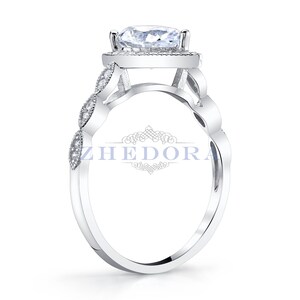 May include: A silver ring with a large, clear, round gemstone surrounded by smaller gemstones. The band is decorated with a delicate, intricate design.