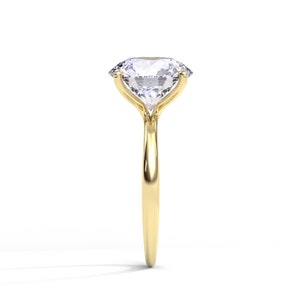 May include: A gold engagement ring with a large, clear, oval-shaped diamond.