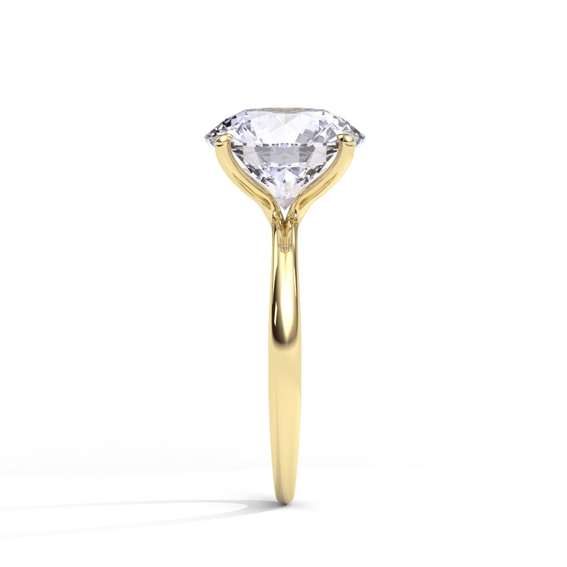 May include: A gold engagement ring with a large, clear, oval-shaped diamond.