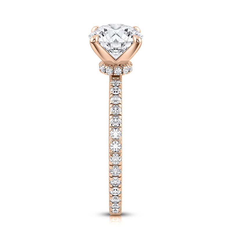 May include: A rose gold engagement ring with a round center stone and a pave diamond band.