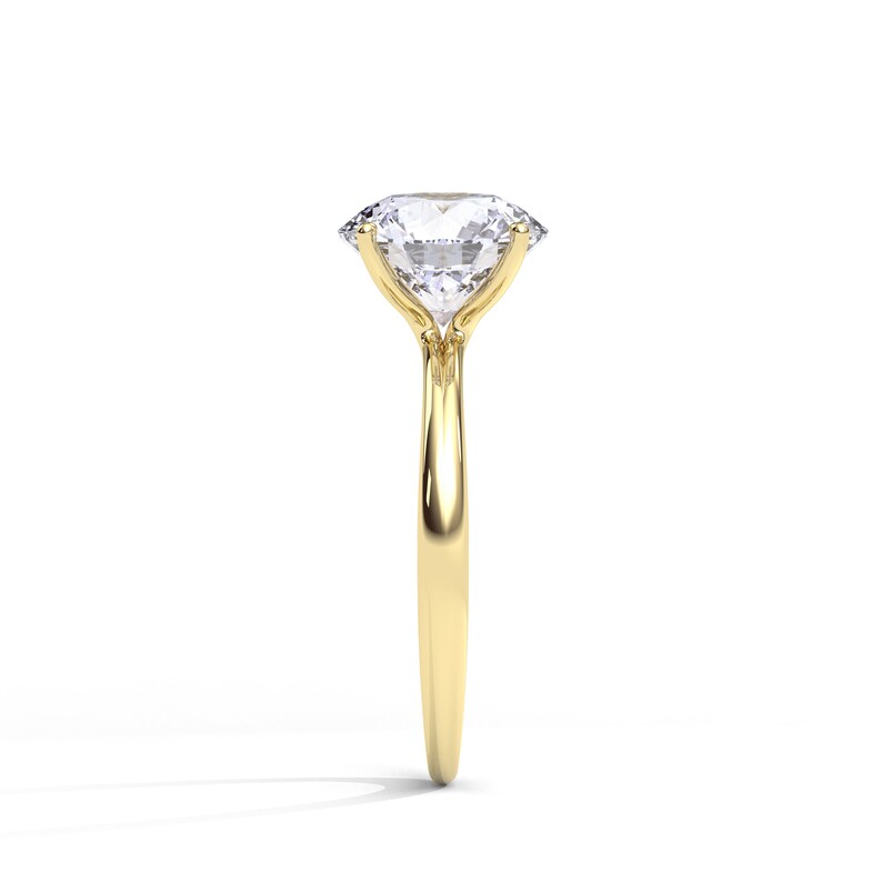 May include: A gold engagement ring with a large, clear, round diamond.