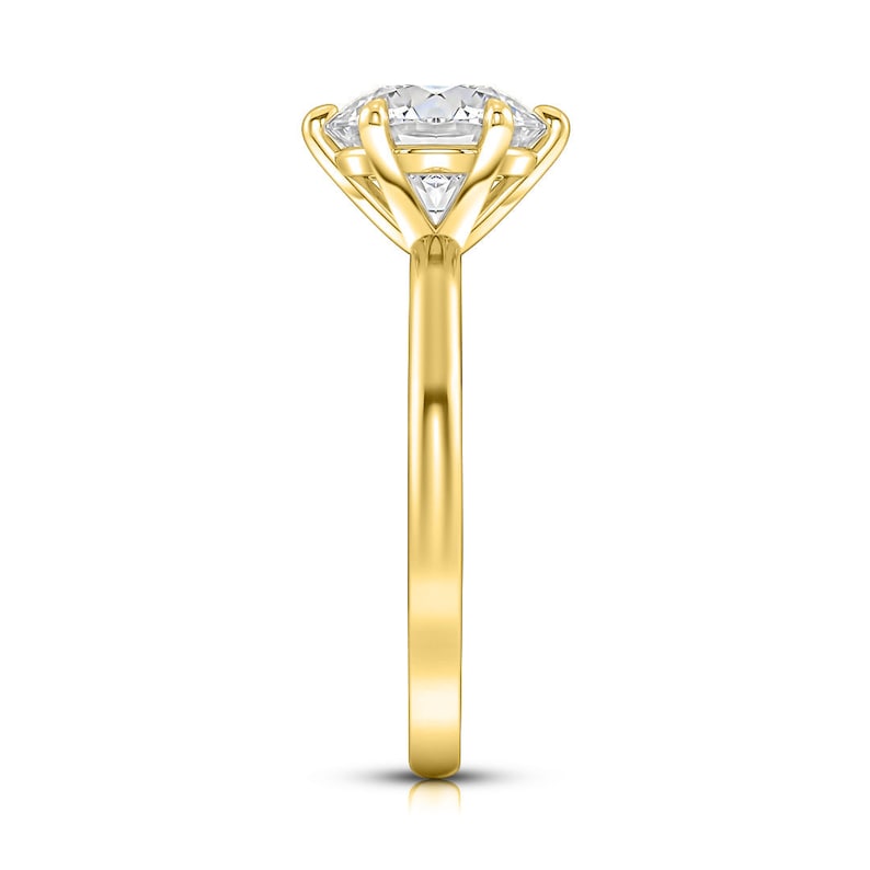 May include: A gold engagement ring with a large, round, clear center stone and two smaller, triangular stones on either side. The ring has a simple band.