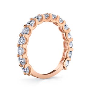 Op de afbeelding: Een rose gouden eeuwigheidsband met een rij ronde briljant geslepen diamanten in pav&eacute; setting.