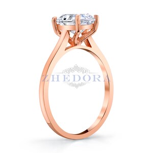 Puede incluir: Un anillo de compromiso de oro rosa con un solo diamante redondo engastado en garras.