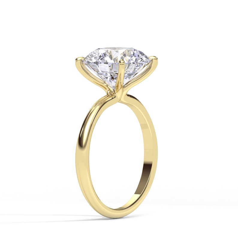 May include: A gold engagement ring with a large, round, clear diamond.