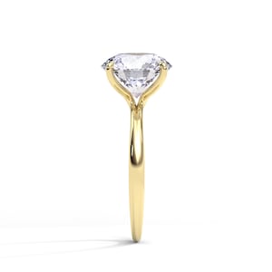 May include: A gold engagement ring with a large, clear, oval-shaped diamond.