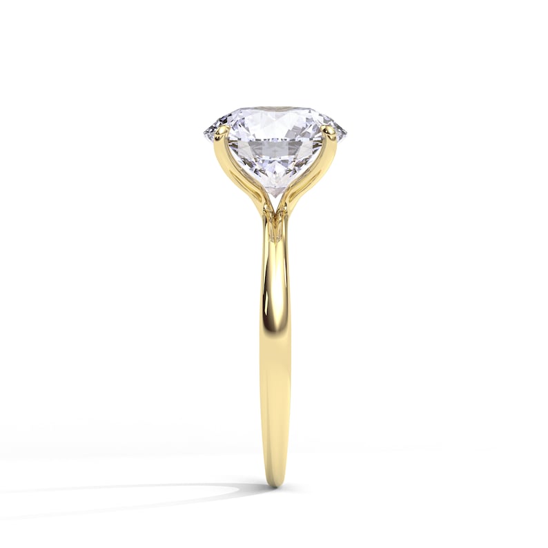 May include: A gold engagement ring with a large, clear, oval-shaped diamond.
