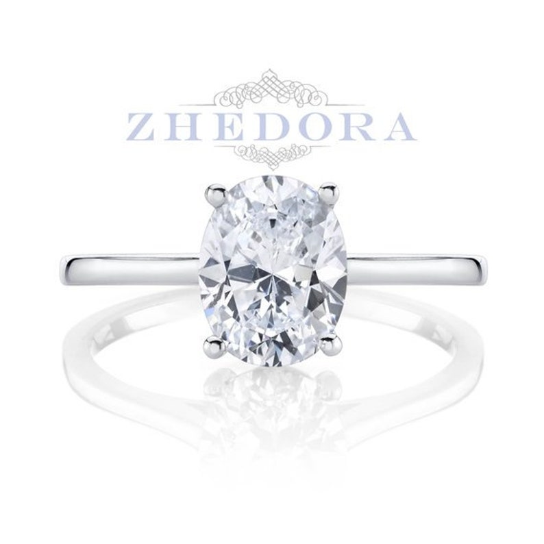 Puede incluir: Un anillo de compromiso de plata con un gran diamante de forma ovalada.