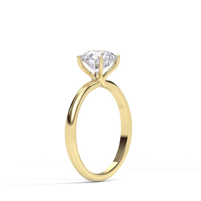 May include: A gold engagement ring with a large, clear, round diamond.