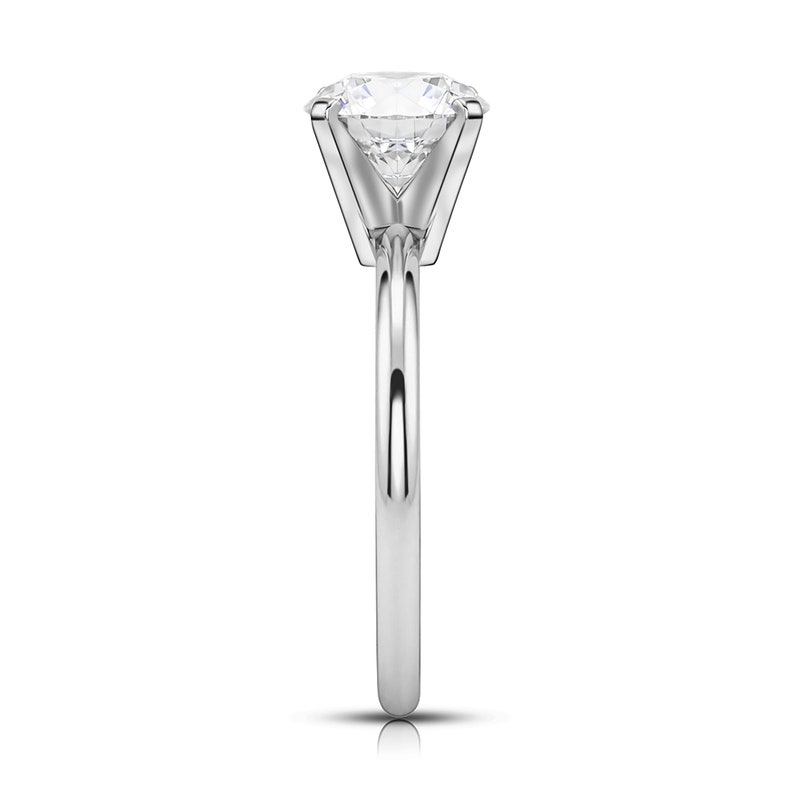 May include: A silver solitaire engagement ring with a large, round, clear diamond.