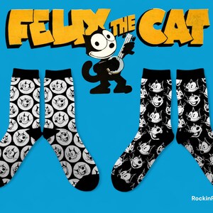 Op de afbeelding: Vier paar zwart-witte sokken met het stripfiguur Felix the Cat. Twee paar hebben een herhalend patroon van Felix' gezicht in witte cirkels, en twee paar hebben een herhalend patroon van Felix' gezicht. De tekst "FELIX THE CAT" is geel.