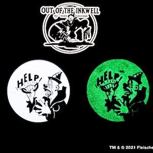 May include: Two black and white cartoon character stickers. One sticker is white with a black cartoon character holding a sign that says "HELP!" The other sticker is green with a black cartoon character holding a sign that says "HELP!" Both stickers have a black and white cartoon character with a hat and a large mouth.
