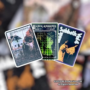 May include: Three vintage Black Sabbath album covers. The first cover is black and white with a house and a figure in the background. The second cover is green and black with a checkered pattern. The third cover is orange and black with a figure in the background. The text on the covers reads "Black Sabbath" and "Sabbath Vol. 4".