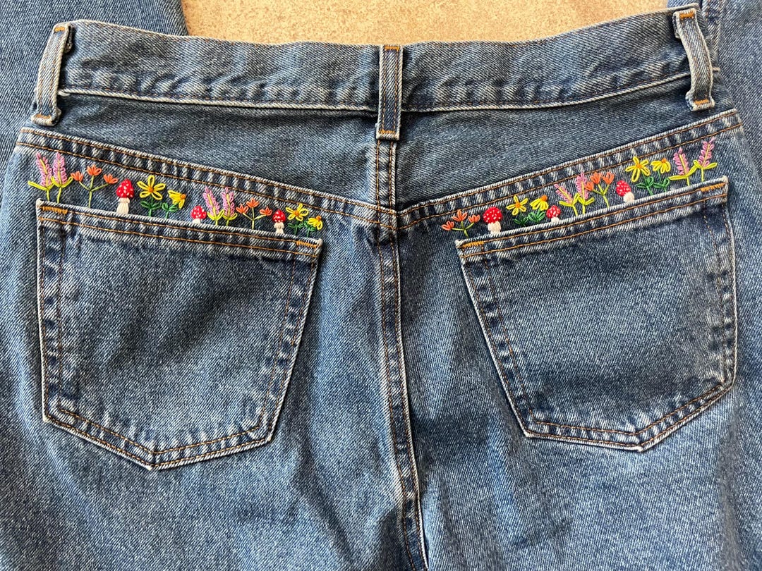 Light blue washed flared jeans with brown floral embroidery
