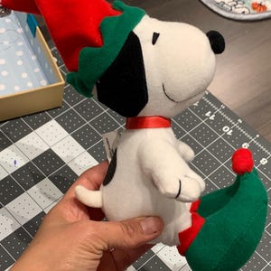 The peanuts toys, plush, snoopy plush, dog plush. Snoopy dressed as Santa Clause&#39;s efl.