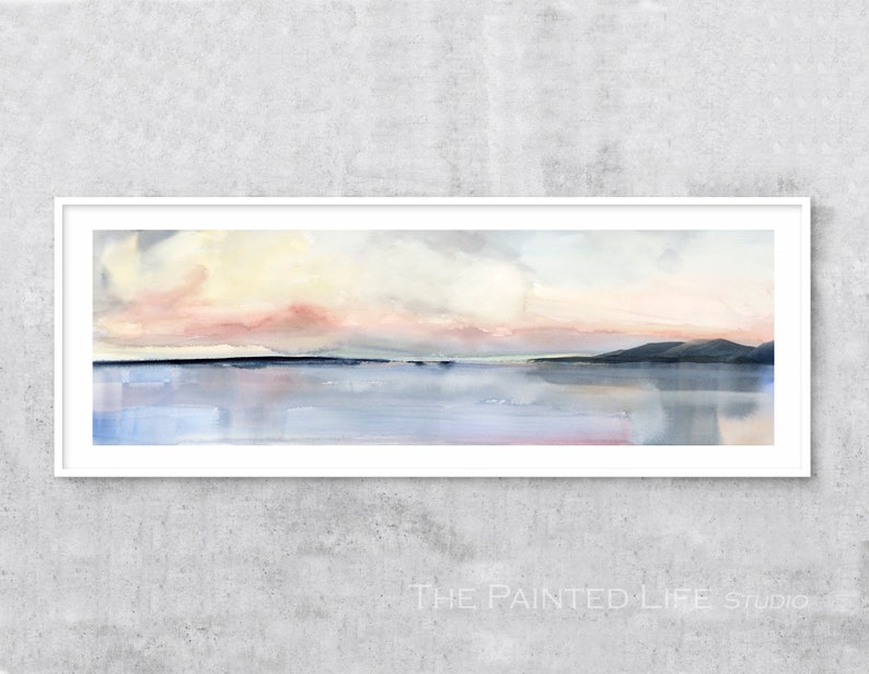 May include: A watercolor painting of a seascape with a pink and yellow sunset over a calm body of water. The painting is framed in a white frame.