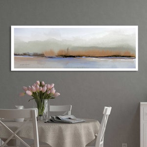 Puede incluir: Una pintura abstracta horizontal larga con un marco blanco. La pintura presenta un esquema de color azul claro, gris y marr&oacute;n con una l&iacute;nea horizontal sutil que representa un horizonte. La pintura est&aacute; colgada en una pared gris sobre una mesa blanca con un mantel blanco y un jarr&oacute;n de tulipanes rosas.