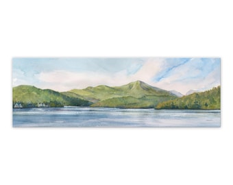 May include: A watercolor painting of a mountain range with a lake in the foreground. The sky is a light blue with white clouds. The mountains are a dark green and the lake is a light blue.