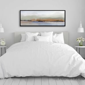 Puede incluir: Una cama blanca con un edred&oacute;n blanco y almohadas blancas en un dormitorio con una pared blanca y una pintura abstracta de paisaje enmarcada en negro sobre la cama.