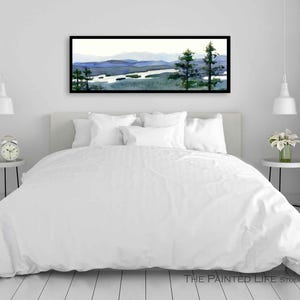 May include: A white bed with a white duvet cover and white pillows. A framed watercolor painting of a lake and mountains hangs above the bed.