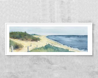 May include: A watercolor painting of a beach scene with a sandy shore, green dunes, and a blue ocean in the distance. The painting is framed in a white frame.