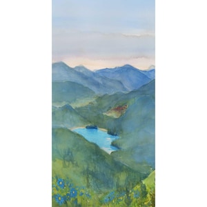 May include: Watercolor painting of a mountain landscape with a lake. The artwork features layers of blue and green hues depicting rolling hills and distant mountains under a pale blue sky. Blue flowers are in the foreground.
