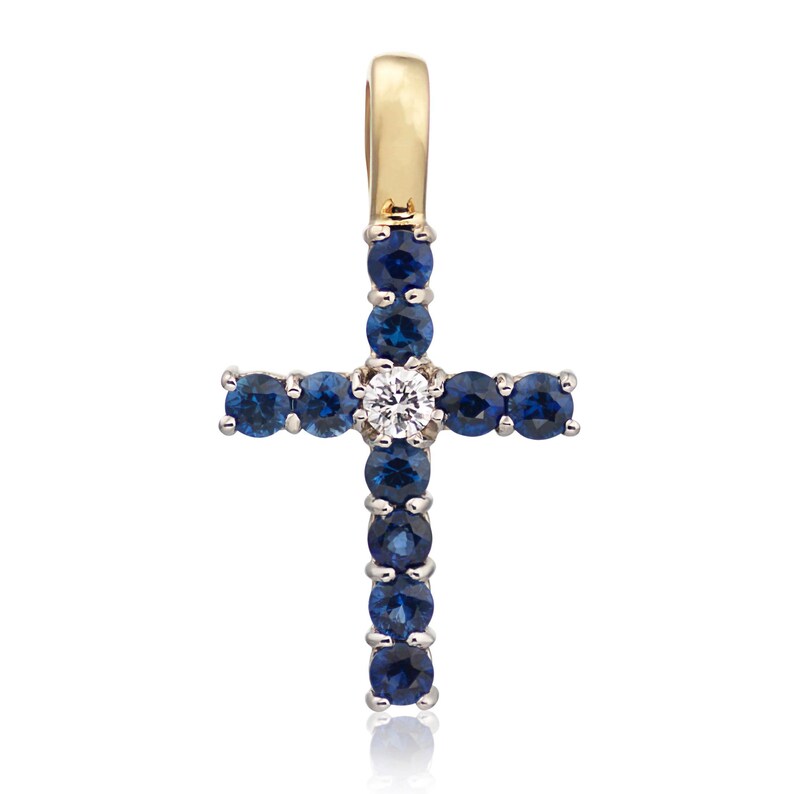 May include: A gold cross pendant with a white diamond in the center and blue sapphires around the edges.
