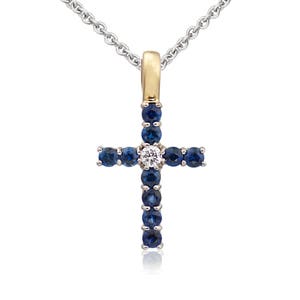 May include: A silver chain necklace with a gold cross pendant. The cross is adorned with blue sapphires and a single white diamond in the center.