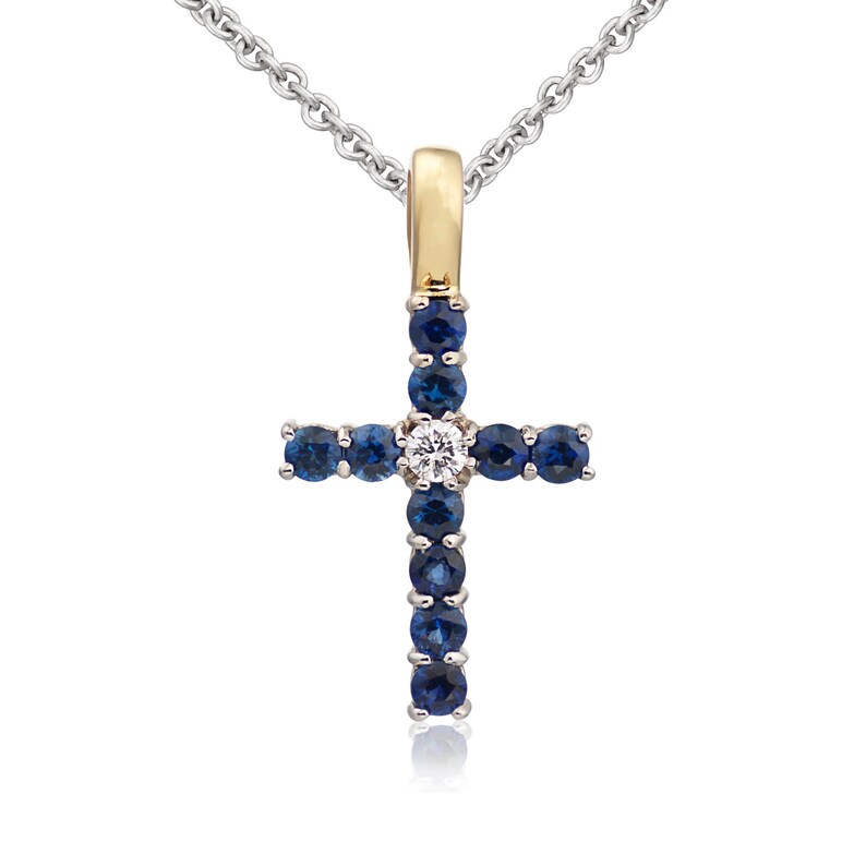 May include: A silver chain necklace with a gold cross pendant. The cross is adorned with blue sapphires and a single white diamond in the center.
