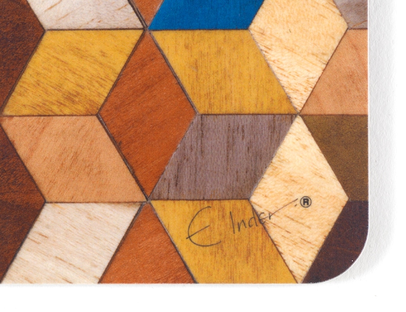 May include: Close-up of a wooden coaster with a geometric pattern. The design features various wood tones, including shades of brown, yellow, and blue, arranged in a repeating diamond shape. The coaster has a white border and the text "E Inder".