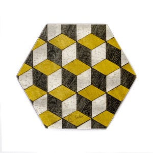 May include: Hexagon-shaped coaster with a geometric pattern of black, white, and gold cubes. The coaster is made of wood and has a distressed finish.