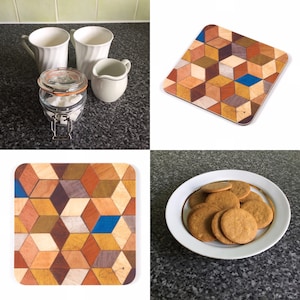 May include: A collection of kitchen items including white mugs, a creamer, a glass jar with sugar cubes, a wooden coaster with a geometric pattern, and a plate of cookies. The coaster features a cube design with various wood tones.