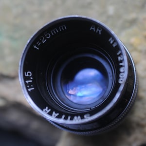 Kern- Paillard AR Switar f:1.5 25 mm C Mount in modest condition with caps and case for 16mm C Some specs of dust inside