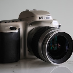 Nikon F50 SLR reflex 35mm film camera + Nikon AF Nikkor 28-80mm f 3.3-5.6 champagne color in good condition
